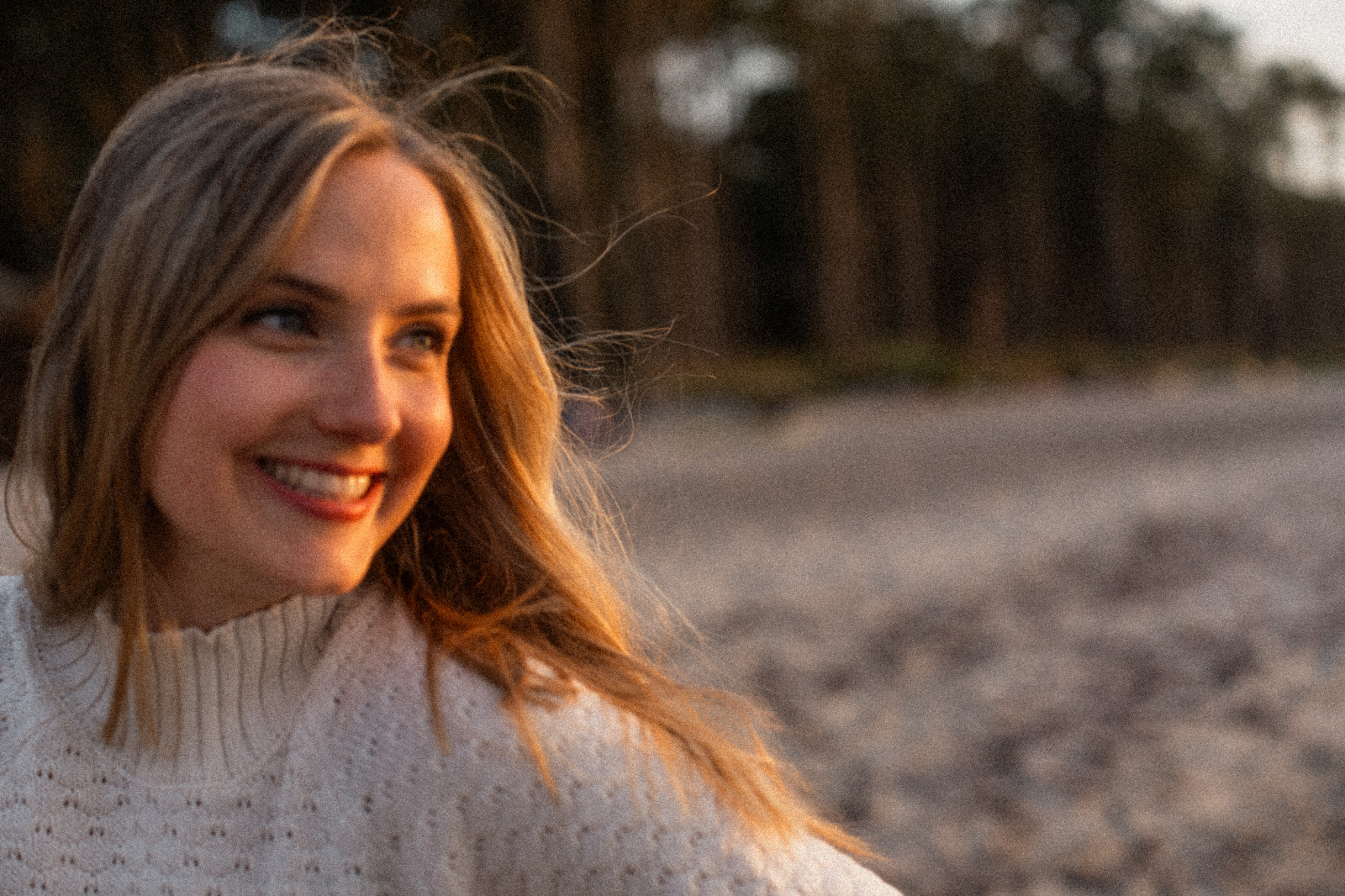 Nora Reinhardt – Stimmtrainerin, lächelnd am Ostseestrand